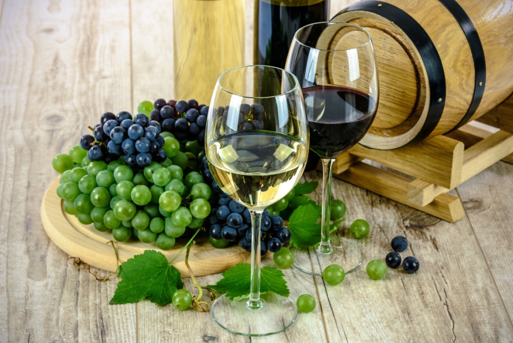 Rødvin i glas og hvidvin i glas, grønne og blå druer